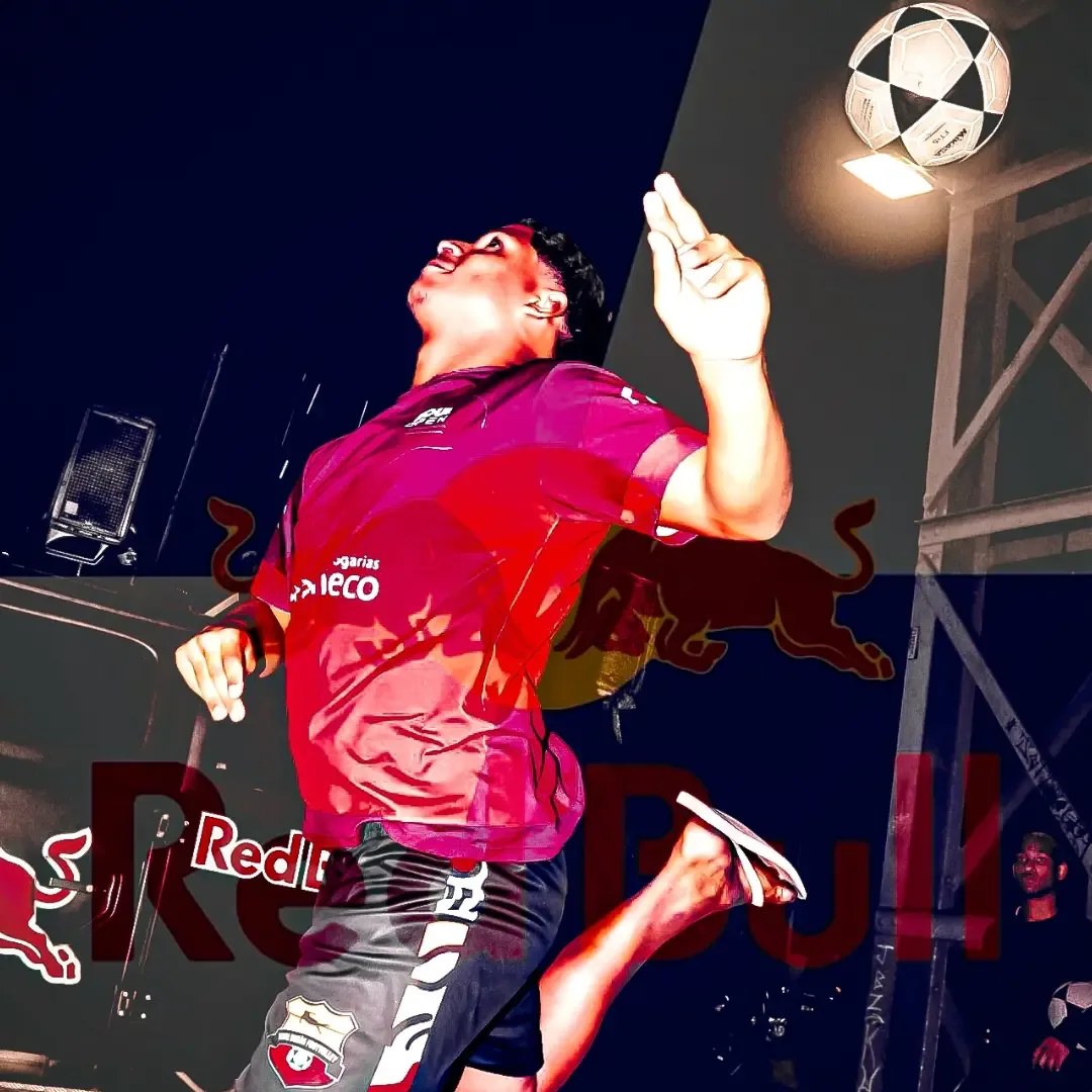 Participante de camisa rosa equilibrando uma bola de futebol junto à cabeça.